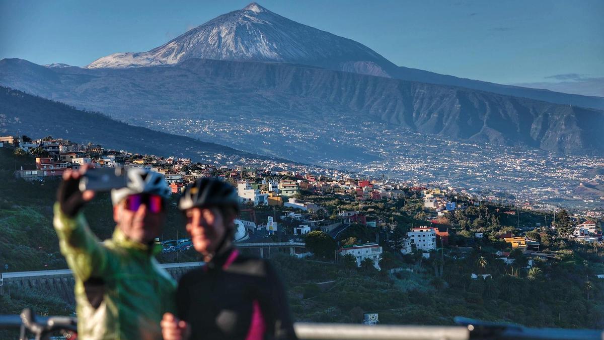 Dos turistas se toman una foto ante el pico del Teide.