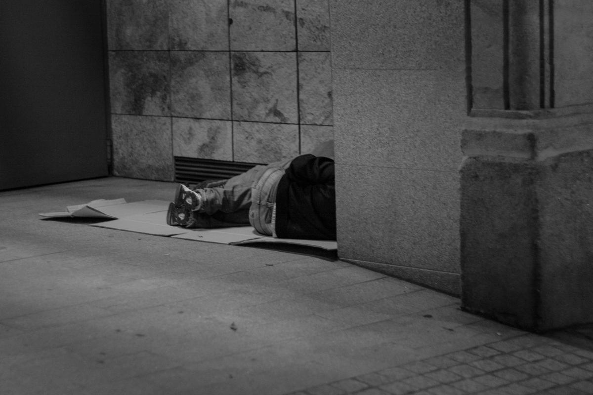 Un hombre, durmiendo en un soportal.