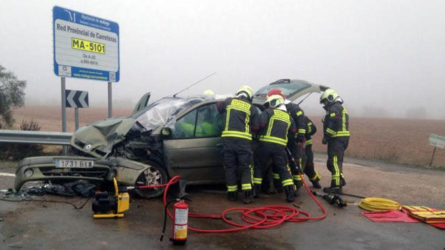 Los bomberos, liberando a uno de los conductores accidentados.