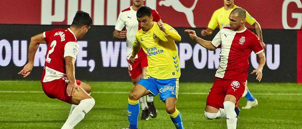 El extremeño Rober González controla el balón ante la presencia de varios jugadores del Girona durante el partido de ayer en Montilivi entre el cuadro catalán y la UD Las Palmas.