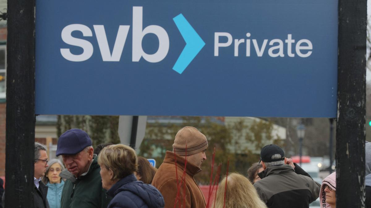 Customers wait in line outside a branch of Silicon Valley Bank in Wellesley