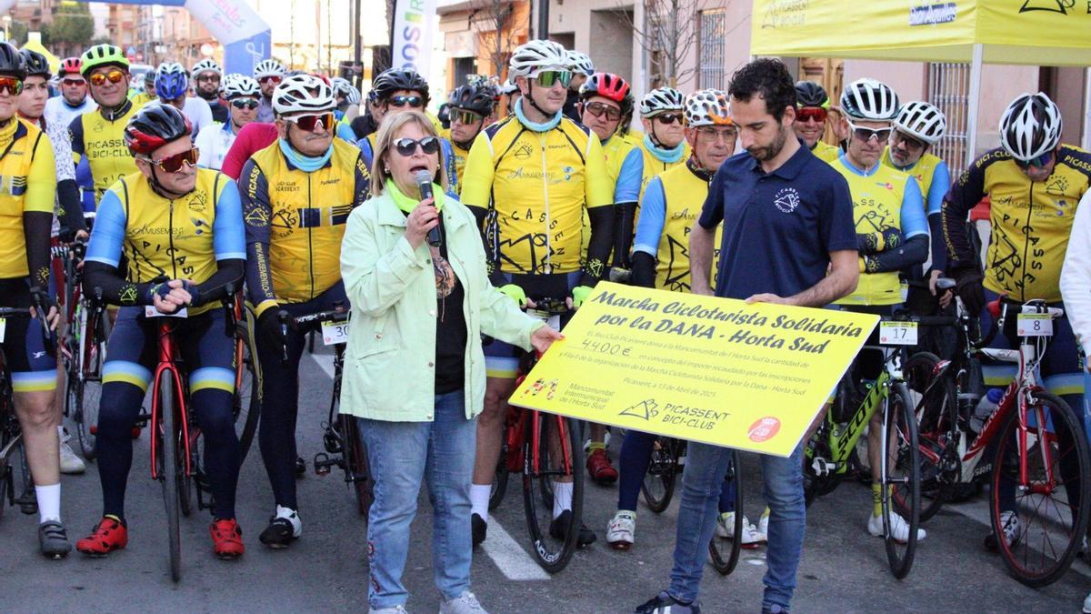 La alcaldesa de Picassent, Conxa Garcia, recoge el cheque del dinero recaudado con la marcha ciclista solidaria