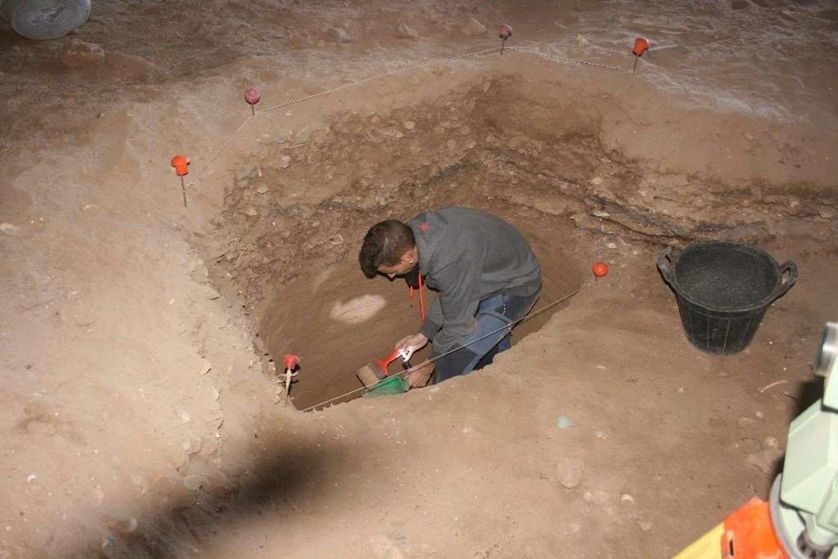 Un arqueologo trabajando en el interior de la cueva de la playa de El Junquillo.