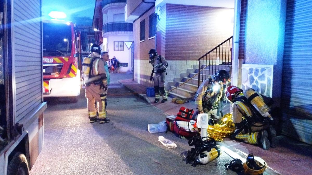 Los bomberos atienden al herido fuera del edificio.