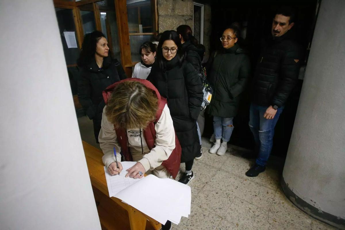 Una trabajadora de Sargadelos firma en la hoja de entrada para atestiguar su presencia en el puesto de trabajo tras encontrarse las puertas cerradas a su llegada a Cervo.
