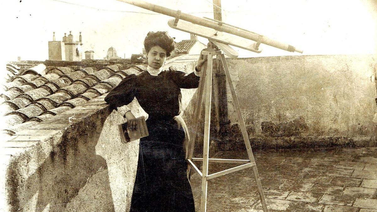 Manolita Carreras al terrat de casa seva, amb el telescopi. A la mà té el llibre Comment étudier les astres, de Lucien Rudaux, editat a París el 1908.  |  COL·LECCIÓ DE LA FAMÍLIA COLL-BOADA