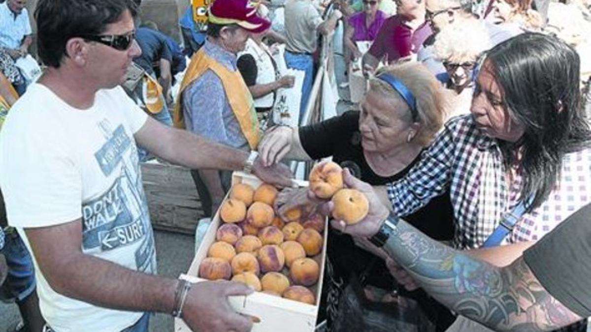 Agricultores reparten melocotones en una protesta del sector en Zaragoza.