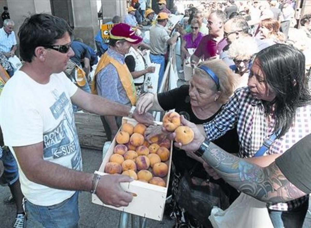 Agricultors reparteixen préssecs en una protesta del sector a Saragossa.