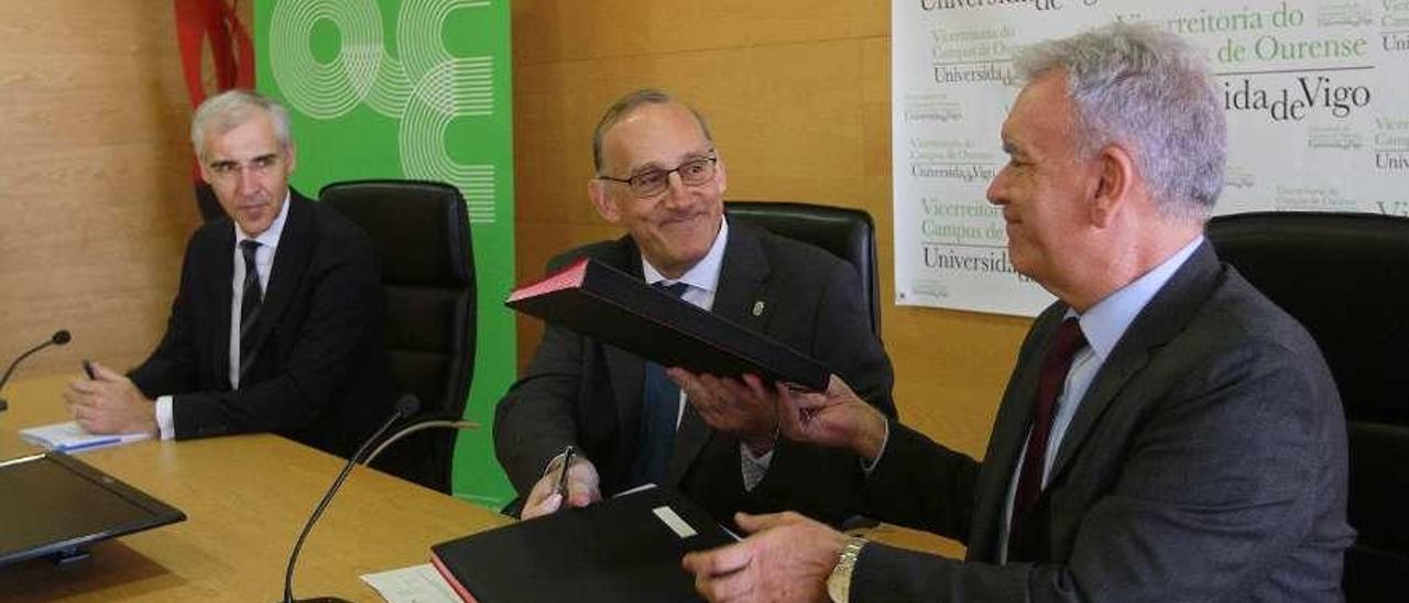 El rector de la UVigo, Manuel Reigosa, y el directivo de Boeing, José Enrique Román, firmaron el convenio en presencia del conselleiro de Economía, Francisco Conde. // Iñaki Osorio