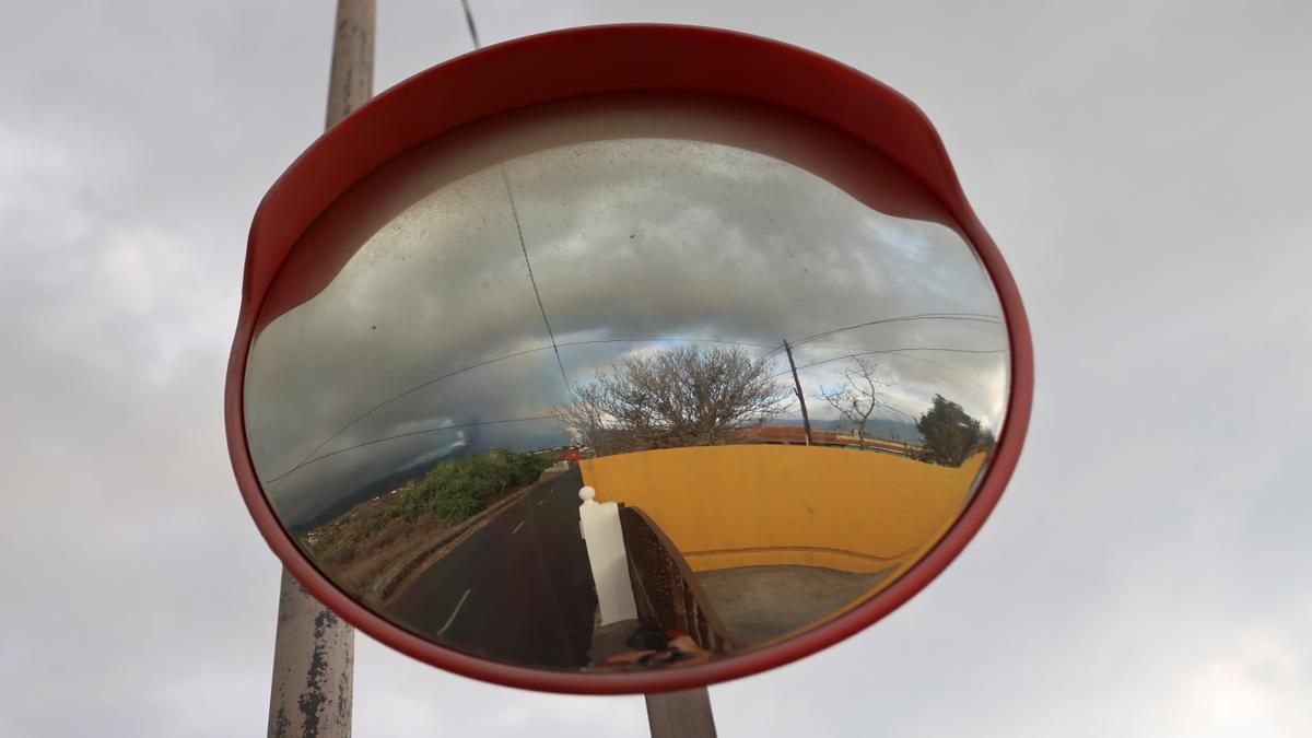 La gran nube de humo y cenizas reflejada en un espejo en la vía pública.