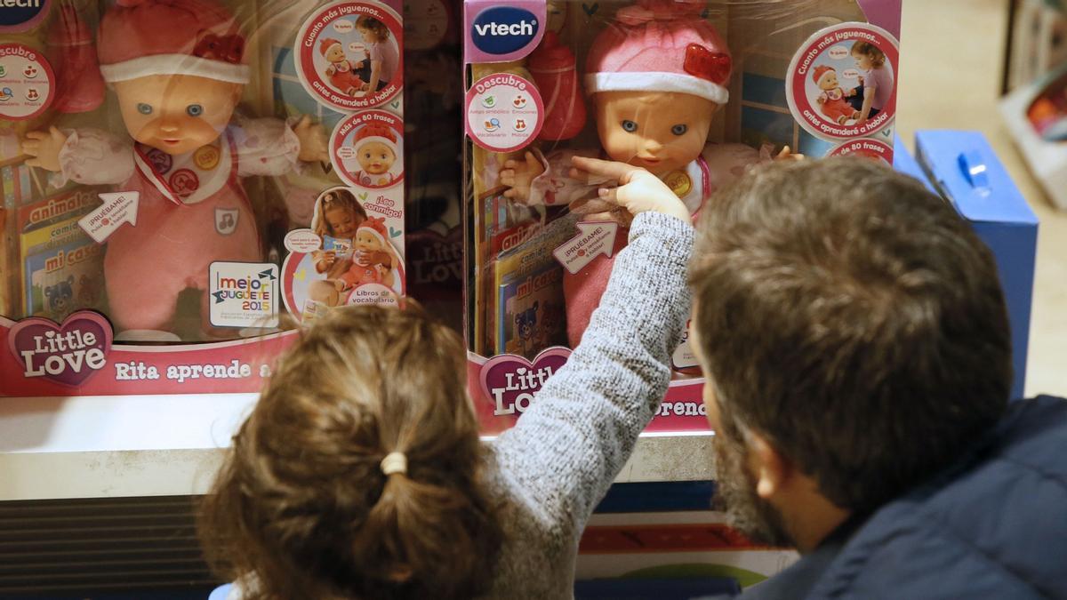 Una niña observa unas muñecas en un centro comercial de Madrid.