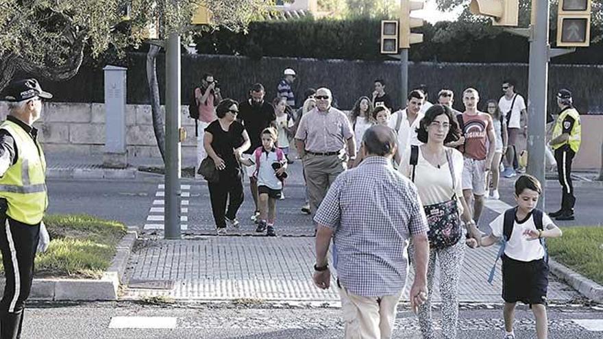 Un policía local supervisa la entrada al colegio en el primer día del curso escolar.