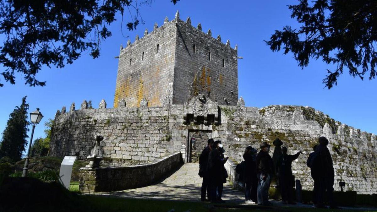 Un grupo de visitantes ante el castillo de Soutomaior.