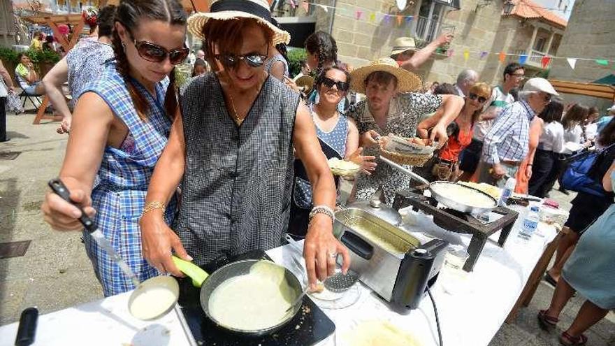 Una mujer prepara filloas durante la romería. // G.S.