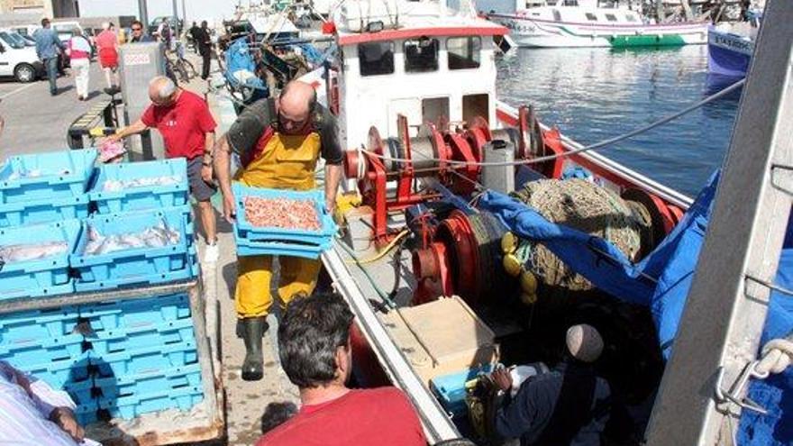 Pescadors feinejant a bord d&#039;una barca.