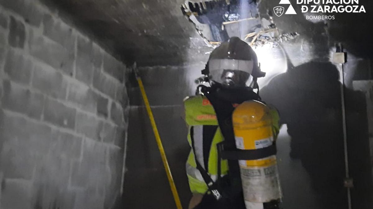 Uno de los bomberos interviene en el edificio quemado en Gallur, este sábado.