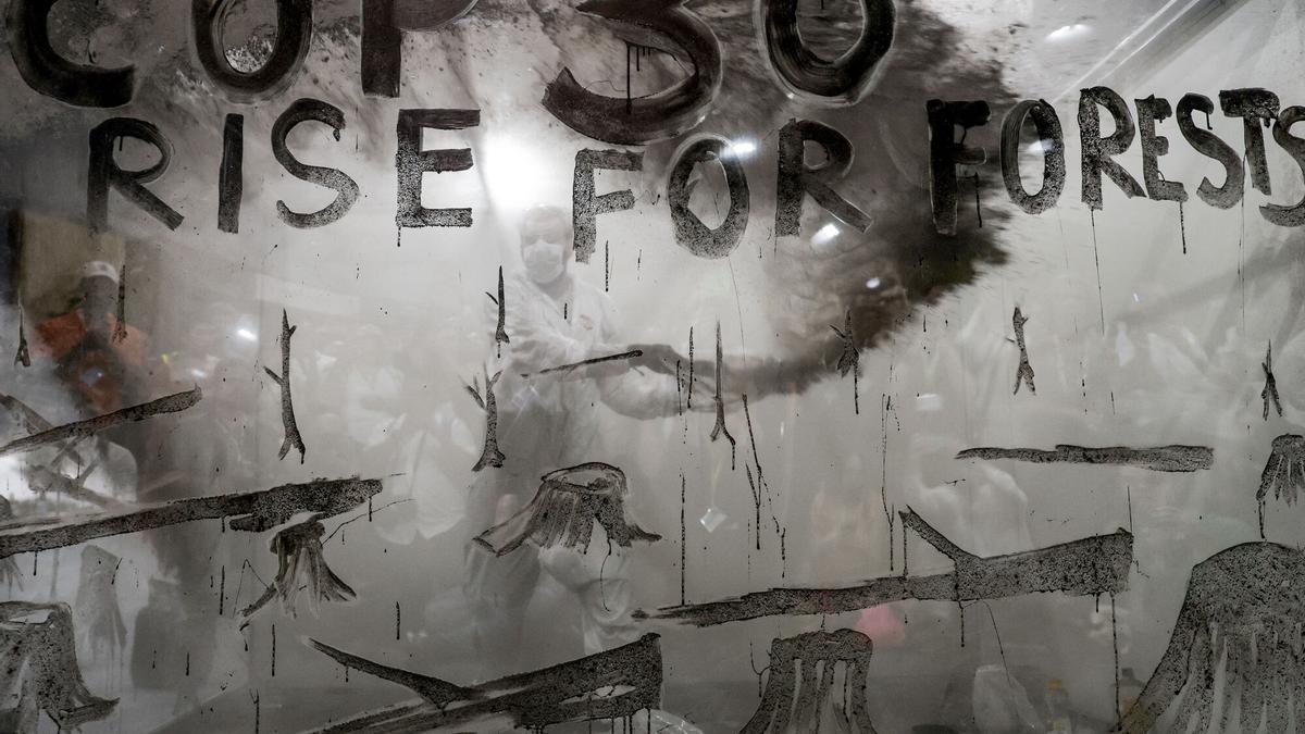 Un artista interviene en la instalación Cenizas del Bosque, obra creada en colaboración con la ONG Greenpeace y presentada en la Zona Azul de la COP30, celebrada en Belém (Brasil).