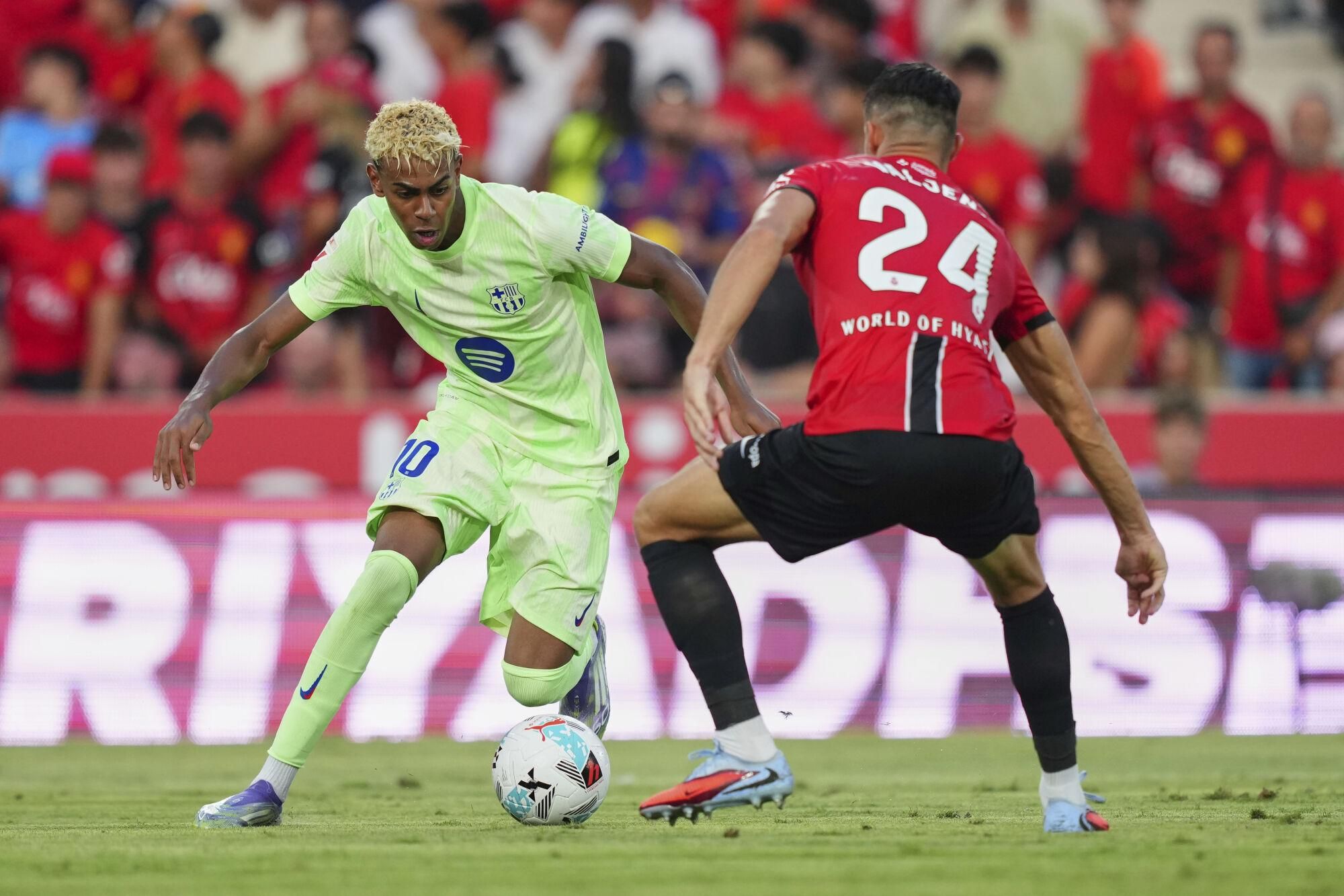 Mallorca's Martin Valjent guards Barcelona's Lamine Yamal during the La Liga soccer match between Mallorca and Barcelona in Mallorca, Spain, Saturday, Aug. 16, 2025. (AP Photo/Joan Mateu Parra)