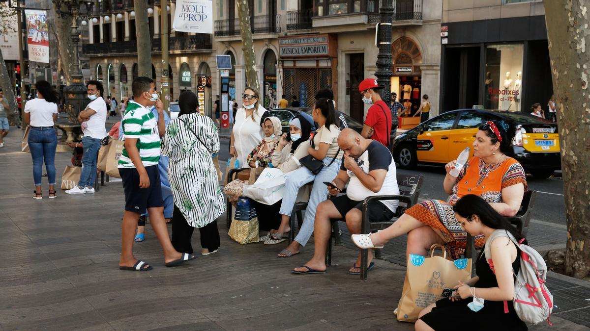 Turistas descansan en un banco de la Rambla, la semana pasada.