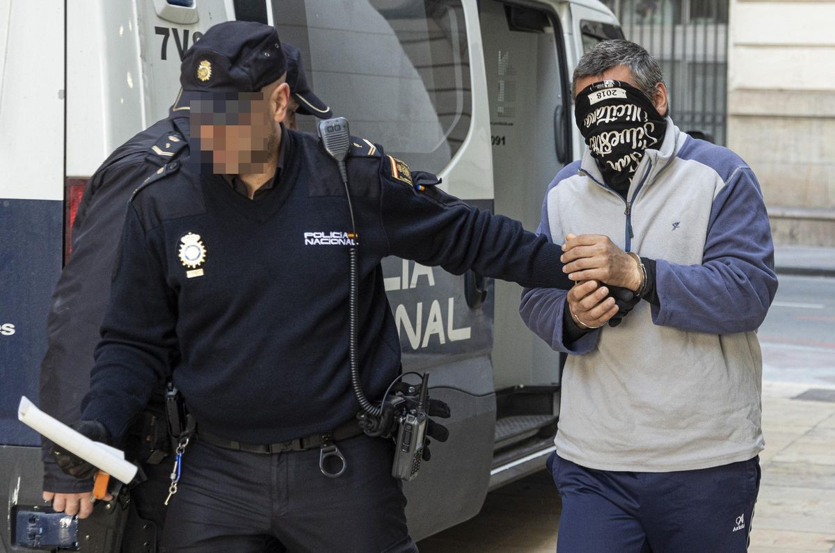 El acusado se tapa la cara al entrar a la Audiencia de Alicante.