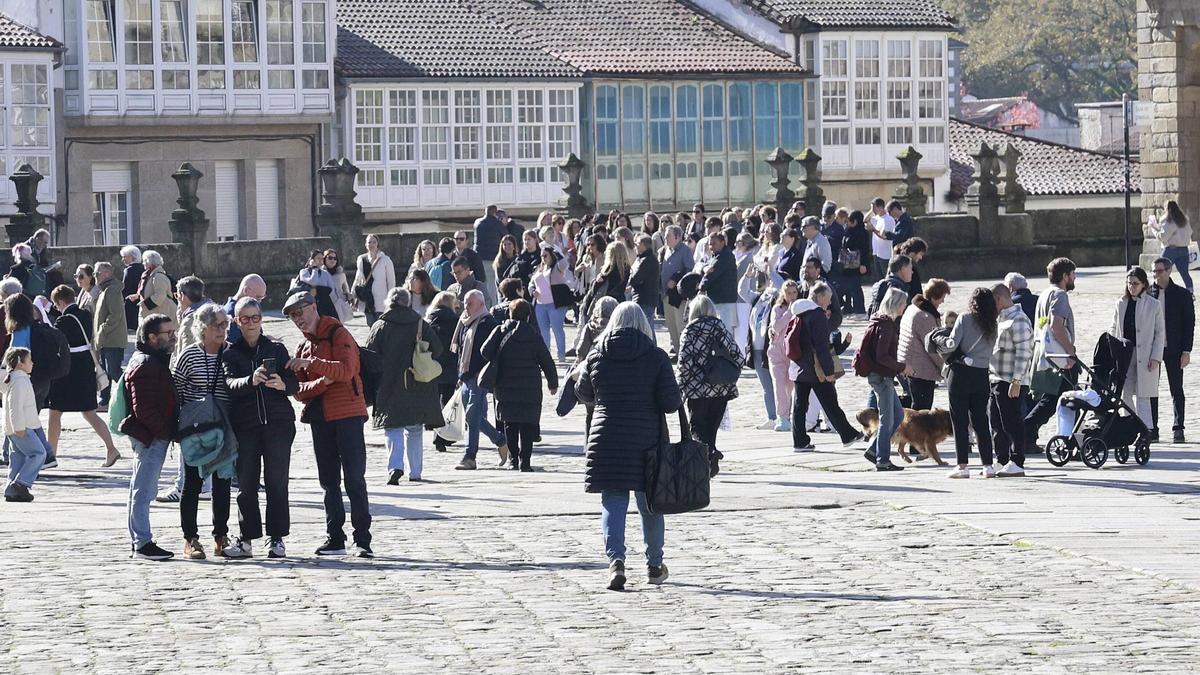 Numerosas personas disfrutan del Obradoiro en una mañana de sábado soleada en Santiago.