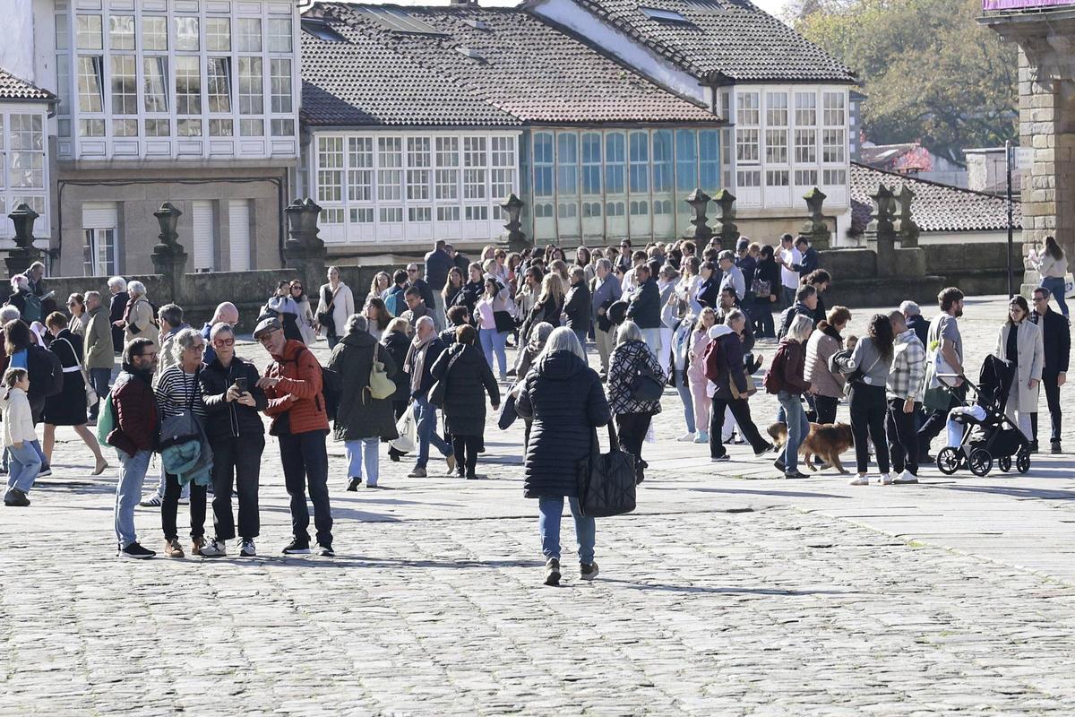 Numerosas personas disfrutan del Obradoiro en una mañana de sábado soleada en Santiago.