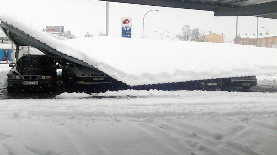 La nieve causa daños en varios vehículos al hundirse el tejado de los aparcamientos en un supermercado en La Lastrilla (Segovia).