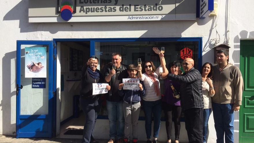 La lotera Tata Betancort, cuarta por la izquierda, brinda este mediodía junto a vecinos y personal del bar cafetería Melania, de Puerto del Carmen, por el segundo premio de la lotería de El Niño.