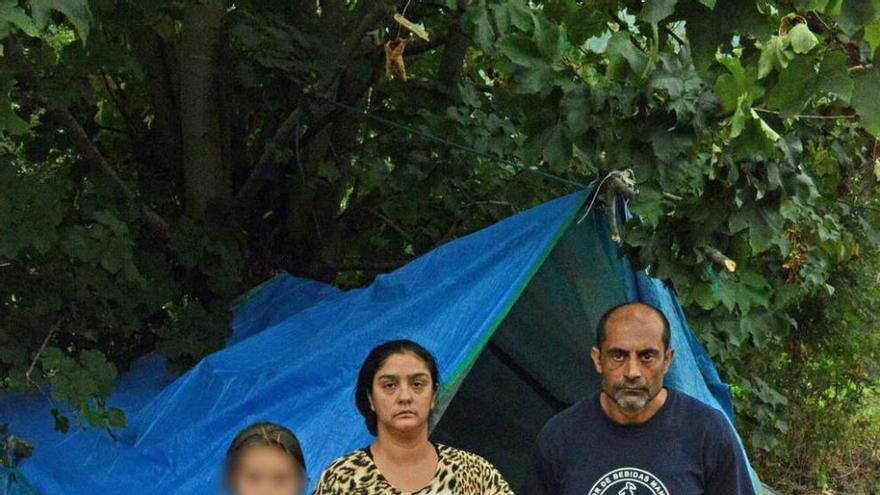 La familia, con tres de los menores, junto a su tienda de campaña.