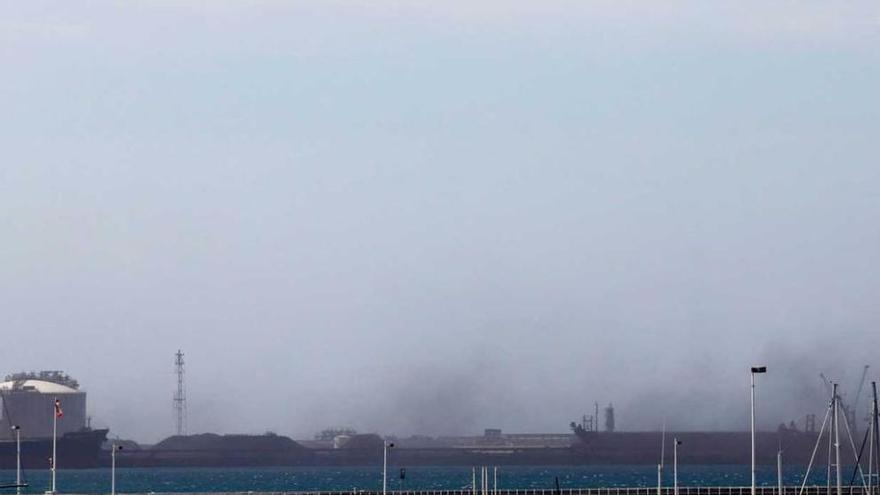 El fuerte viento levanta una nube de carbón en El Musel