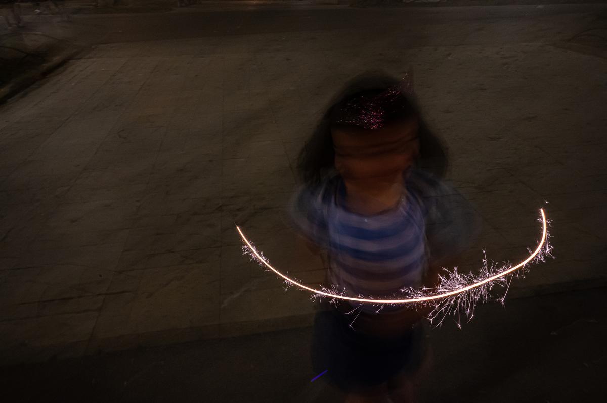  Una niña juega con una bengala cerca de Arc de Triomf de Barcelona.