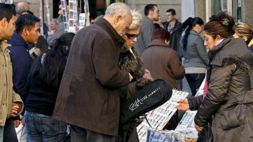 Vendedores de lotería atienden en la Puerta del Sol a compradores que desean participar en el sorteo navideño.