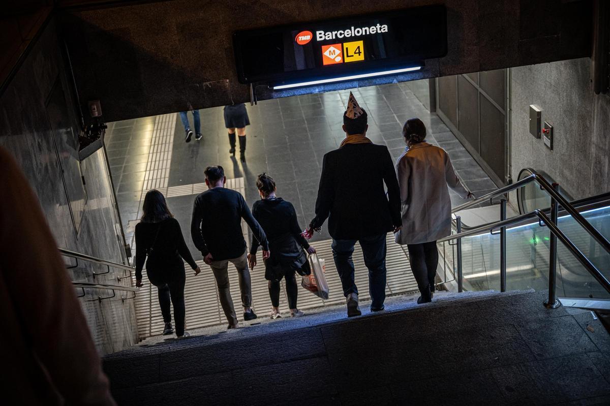 Varias personas entran el metro tras una breve fiesta en la calle.