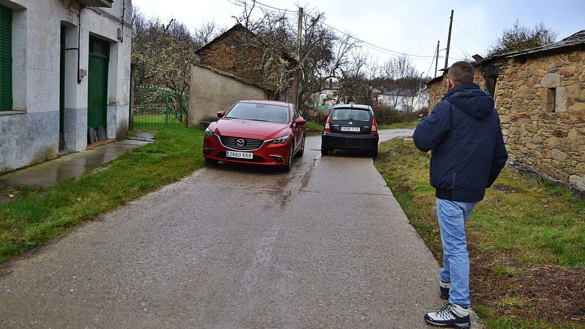 Un vecino observa dos coches que se cruzan en la carretera que atraviesa el pueblo de Otero y que lleva a la estación del AVE. | Araceli Saavedra