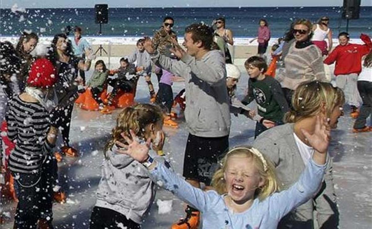 Turistes i natius disfruten de la neu a la platja de Bondi a Sydney, Austràlia.