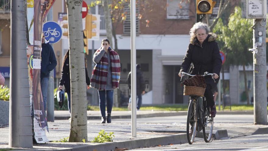 Una dona circula amb bicicleta per la ciutat de Girona