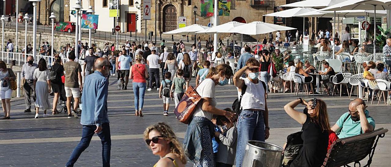 Paseantes por el puerto deportivo, a la altura de los Jardines de la Reina.