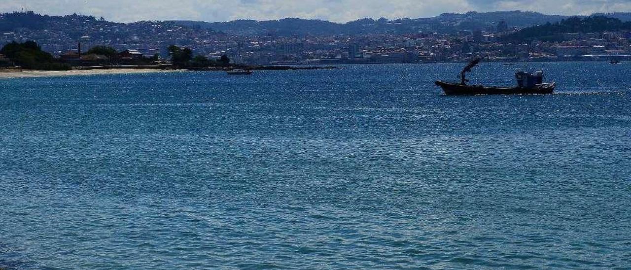 El barco que se encarga del arado de los fondos trabajando delante de la playa de Rodeira, en Cangas. // Gonzalo Núñez