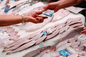 Un consumidor paga en una pescadería.