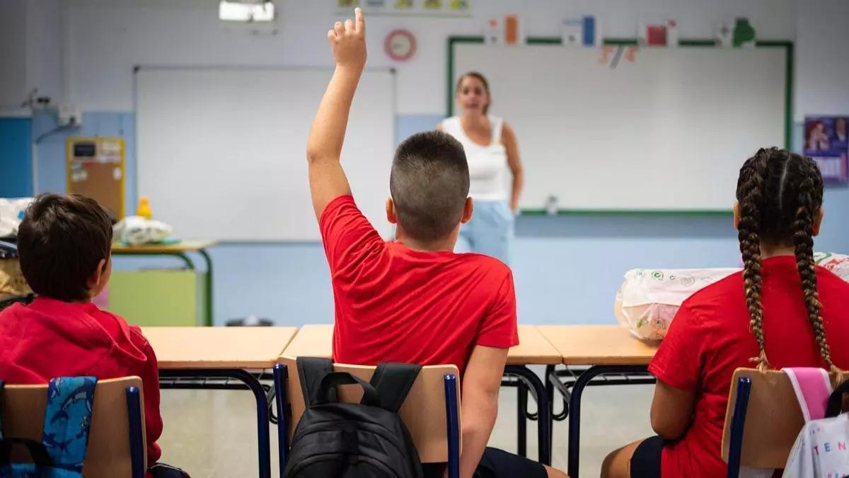Una profesora atiende a un alumno.