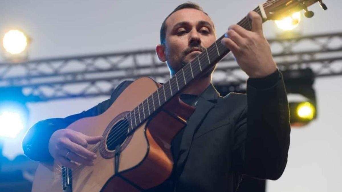 Antonio González acariciando las cuerdas de su guitarra.