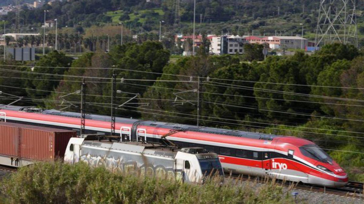 Un tren d’alta velocitat circula al costat d’un de mercaderies. Un tren d’alta velocitat circula al costat d’un de mercaderies.