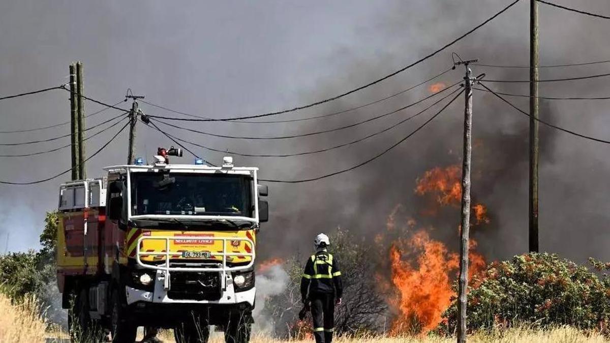 Un bomber francés camina al costat de l'incendi