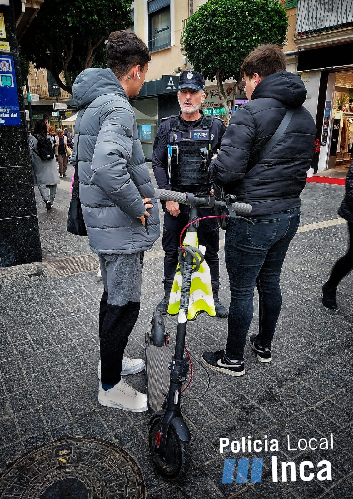 Un agente policial intercepta a dos jóvenes que circulaban en un patinete eléctrico.