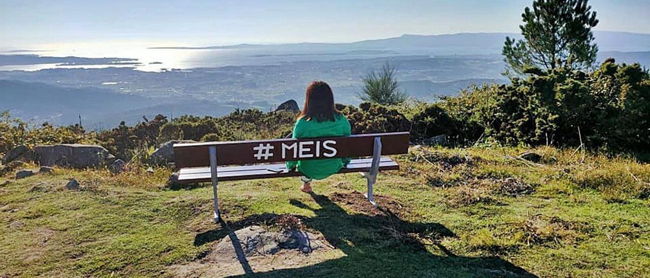 Marta Giráldez, alcaldesa de Meis, observa el horizonte desde el banco de Monte Castrove.