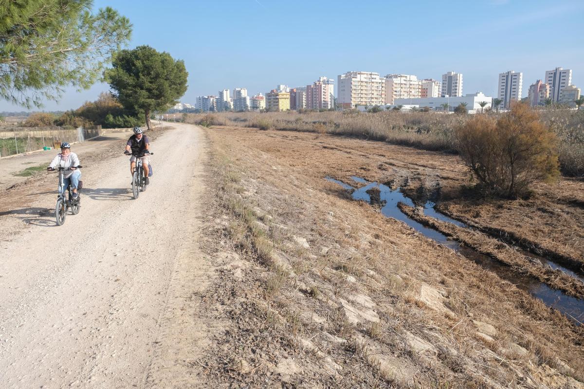 El cauce nuevo junto a la desembocadura es una zona de tránsito habitual de bicicletas y peatones junto a la mota del río. A la derecha, la maquinaria ha respetado un ejemplar de taray
