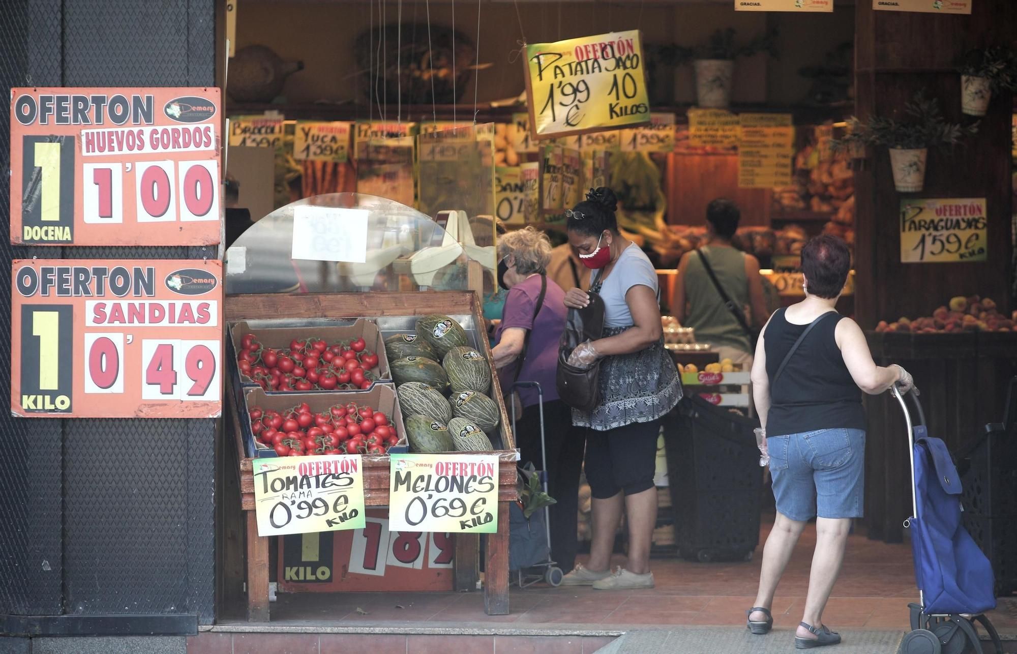 Archivo - Varias personas compran en una frutería