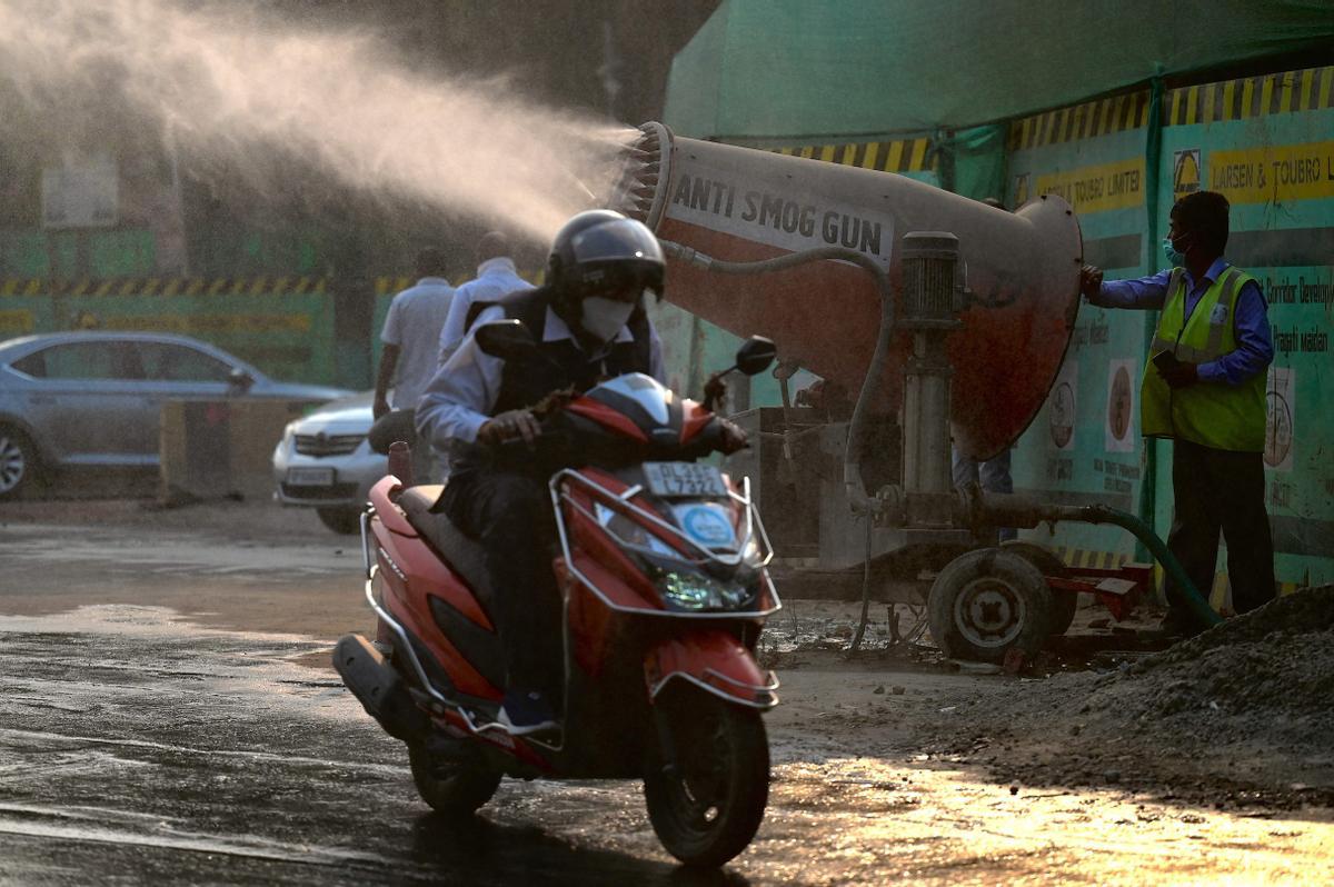 Un cañón anticontaminación lanza agua a las contaminadas calles de Nueva Delhi.