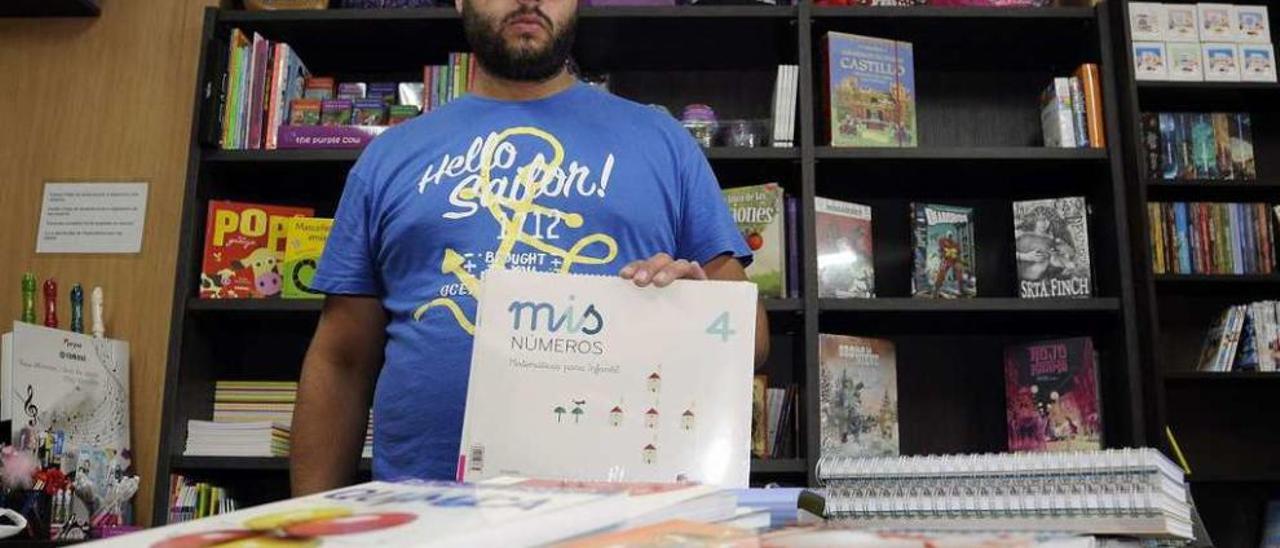 Iago González, de la librería Vagalume, con algunos de los libros escolares. // Bernabé/JavierLalín