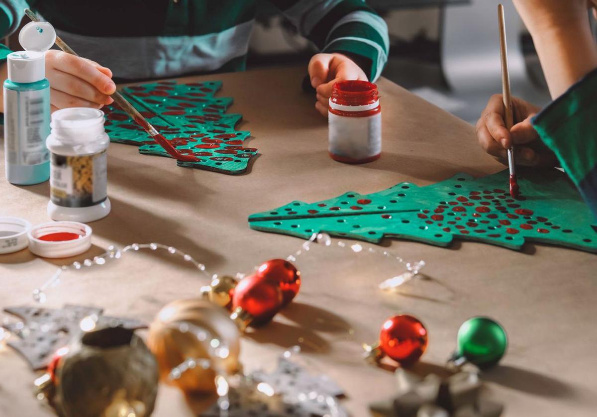 De madera o de cartón, decorar árboles navideños es una opción sencilla para los niños.